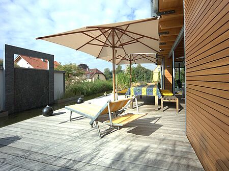 Die Holzbauweise lädt zum gemütlichen verweilen auf der Terrasse ein