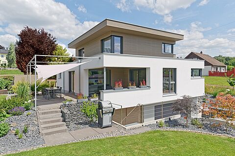 Holzhaus mit Flachdach und umlaufender Dachterrasse